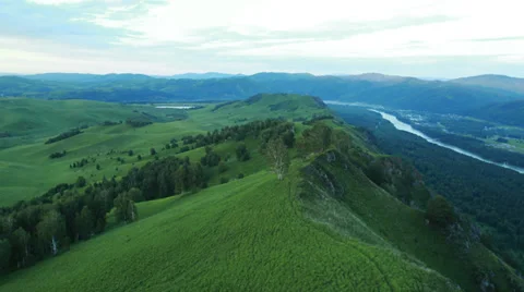 Aerial View. Sunset. Flight over a green grassy rocky hills. Stock Footage 35219337