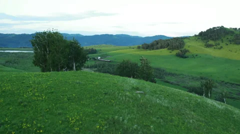 Aerial View. Sunset. Flight over a green grassy rocky hills. Stock Footage 35219763