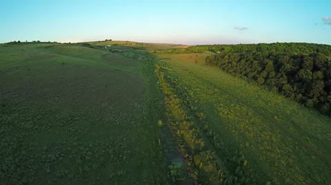 Aerial View, Sunset Flight over a green grassy hills. Vidéo 65037084
