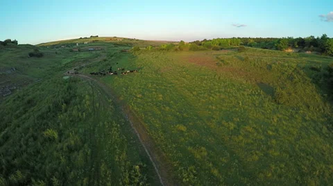 Aerial View, Sunset Flight over a green grassy hills. Stockbeeldmateriaal 65037298