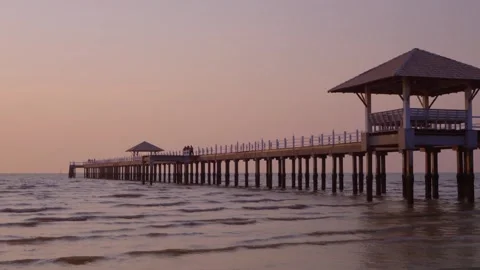 Aerial view of the sunset horizon over the sea. There is a pier extending o.. Vidéo 265042017