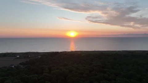 Aerial View of Sunset over Calm Ocean and Coastal Landscape Stock Footage 341904829