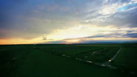Aerial view of sunset over a field of green wheat in late spring Stock Footage 63186349