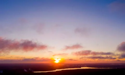 Aerial view sunset over the forest and lake. Top view. View from drone. Aeria Stock Photos