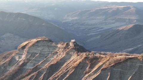 Aerial view of Sunset over a mountaintop chape Video stock 272233098
