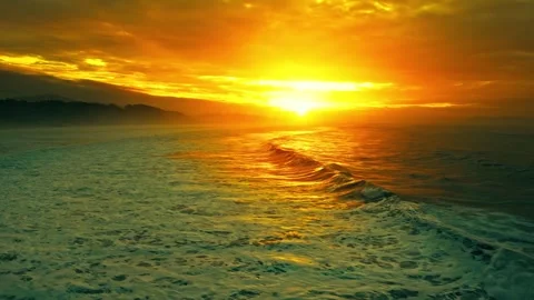 Aerial view of sunset over ocean waves with golden light and clouds. Stock-Footage 341073134