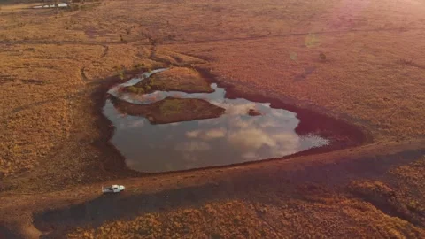 Aerial view of sunset over outback landscape with pond, Australia. Stock Footage 284819853