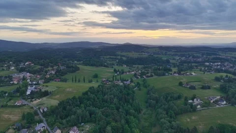 Aerial view of sunset over rolling countryside with patchwork fields, villages, Stock Footage 347913914