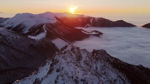 Aerial View of Sunset Over Snow-Covered Rocky Peaks, with Fog Blanketing the 스톡 동영상 301647548
