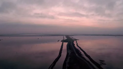 Aerial view of sunset reflection on lake with road Stock Footage 47947362