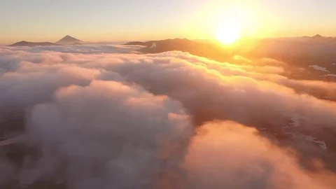 Aerial View. Sunset. The sun comes in the clouds behind the mountains Stock Footage 72657585