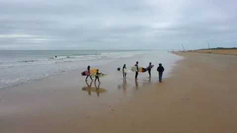 Aerial view of surf school going out the sea water and walking on beach Stock Footage 144552841