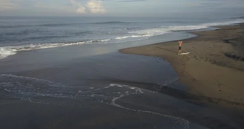 Aerial view of surfer at the beach Stock Footage 128422204