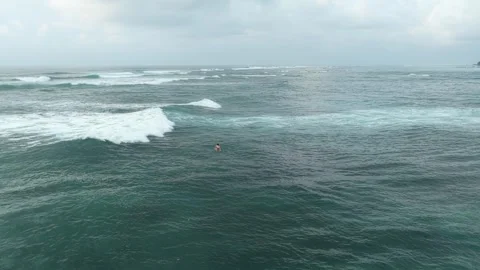 Aerial view of surfer catching wave in tropical ocean Stock Footage 328924151