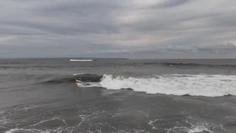 Aerial view of surfer on the wave on Canggu beach. Bali, Indonesia Stock Footage 320210139