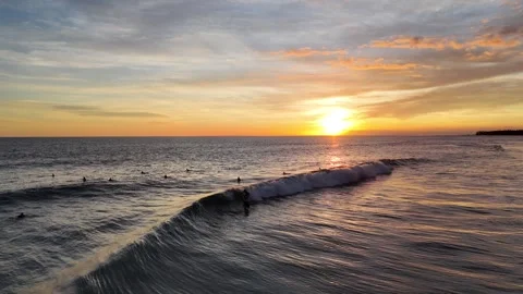 Aerial view of surfer on the wave on Canggu beach at sunset. Bali, Indonesia Stock Footage 320376973