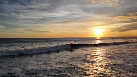 Aerial view of surfer on the wave on Canggu beach at sunset. Bali, Indonesia Stock Footage 320377064