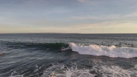 Aerial view of surfer on the wave on Canggu beach at sunset. Bali, Indonesia Stock Footage 320378461