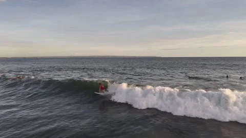 Aerial view of surfer on the wave on Canggu beach at sunset. Bali, Indonesia Stock Footage 320378474