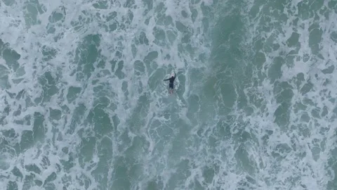 Aerial view - surfer on the waves duck dive Stock Footage 228438335