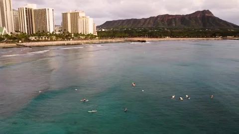 Aerial view of surfers awaiting waves at waikiki beach with diamond head crater Video stock 337639746