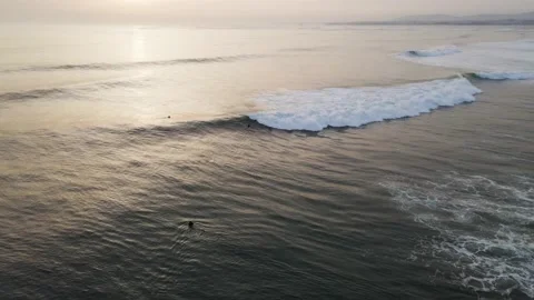 Aerial view of surfers riding waves in Caparica, Lisbon, Portugal. Stock Footage 152746563