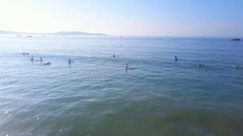 Aerial view surfers waiting for waves in lineup drone footage Stock Footage 84824112