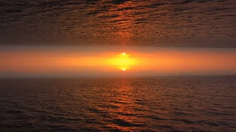 Aerial view on surreal upside down mirrored world, orange sun and sea on Stock Footage 121613430