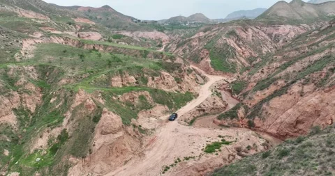 Aerial View Of SUV Driving On Dirt Road In Danxia Valley Vidéo 312933183