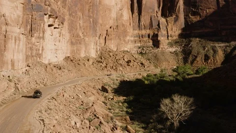 Aerial View Of SUV Driving Through A Desert Canyon 스톡 동영상 100518906