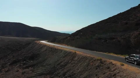Aerial View | SUV driving through Jordan Desert Rock Formation Stock Footage 141763693