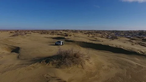 Aerial view of suv moving in the snow-capped desert in winter. Western Stock Footage 80244055