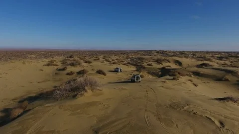 Aerial view of suv moving in the snow-capped desert in winter. Western Stock Footage 80244102