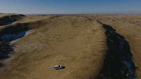 Aerial view of suvs moving through the snow-covered desert in winter. Western Stock Footage 93686757