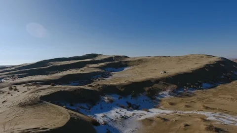 Aerial view of suvs moving through the snow-covered desert in winter. Western Stock Footage 93687294
