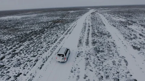 Aerial view of suvs moving through the snow-covered desert in winter. Western Stock Footage 93688859