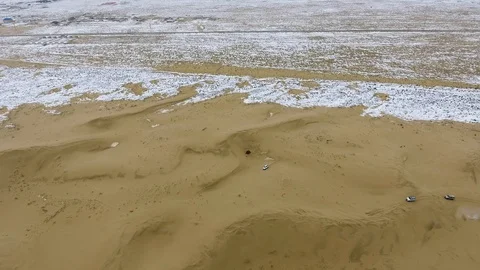 Aerial view of suvs moving through the snow-covered desert in winter. Western Stock Footage 93741006