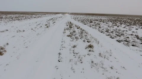 Aerial view of suvs moving through the snow-covered desert in winter. Western Stock Footage 93741533