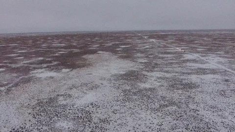 Aerial view of suvs moving through the snow-covered desert in winter. Western Stock Footage 93832476