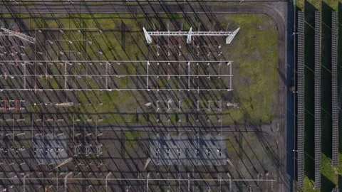 Aerial view of a symmetrical grid of electrical infrastructure casting long Stock Footage 332313134