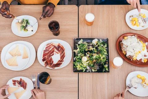 Aerial view of a table with serrano ham, manchego cheese, salad and meat Stock Photos