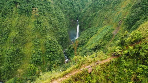 Aerial view of tall waterfall surrounded by lush green mountains in Costa Rica Stock Footage 344914280