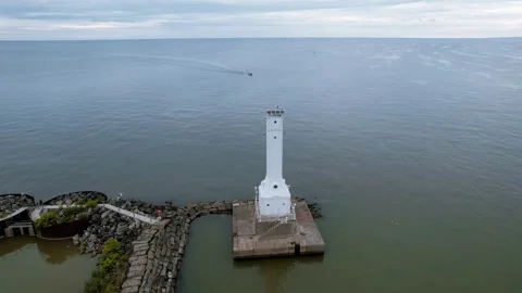 Aerial view of tall white Huron Harbor Lighthousein Lake Erie, Ohio. At the.. Stock Footage 322960733