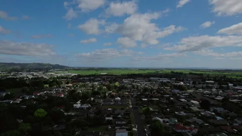 Aerial view of Te Puke town with fields and mountains under a bright, clear sky Stock Footage 301373616