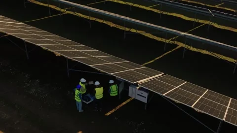 Aerial view of technical engineers inspecting solar panel array farm instal.. Stock Footage 337613445