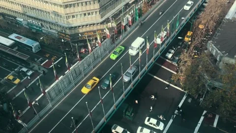 Aerial view of Tehran bridge with lined Iranian flags and traffic below Stock Footage 335946808