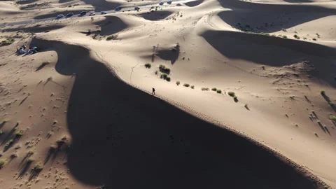 Aerial View of Tengger Desert Dunes with Hiker and Vehicles Stock Footage 345370326