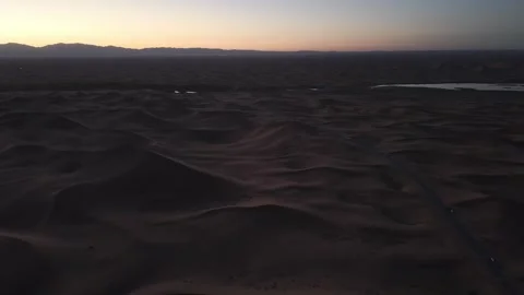 Aerial view of Tengger Desert dunes at dusk with oasis and road 스톡 동영상 345370419