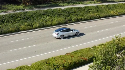 Aerial view of Tesla Model 3 Performance electric vehicle or EV car driving Stock Footage