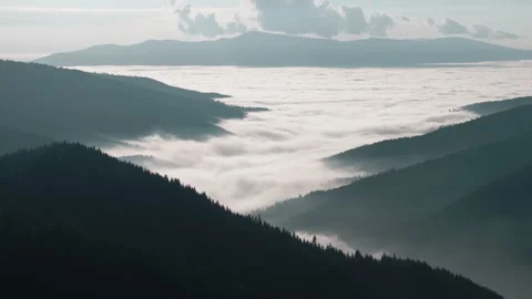 Aerial View of a Thick Blanket of Clouds Nestled Between Mountain Ranges Stock-Footage 331060511